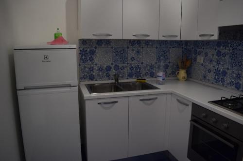a kitchen with white cabinets and a sink at La Casa di Cirro in Procida