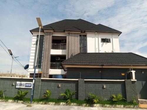a house with a fence in front of it at Ike Service Apartments in Owerri