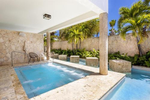 a swimming pool with a table and a chair next to a house at Hyatt Regency Grand Reserve Puerto Rico in Rio Grande