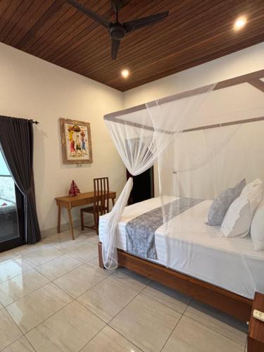 a bedroom with a bed with a mosquito net at Villa Ganesha Penuktukan in Tejakula