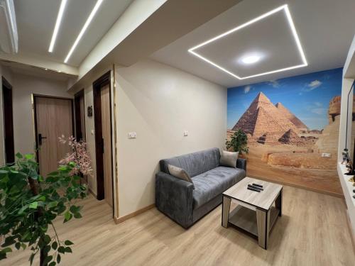 a living room with a couch and a painting of the pyramids at Pyramids View Inn in Cairo