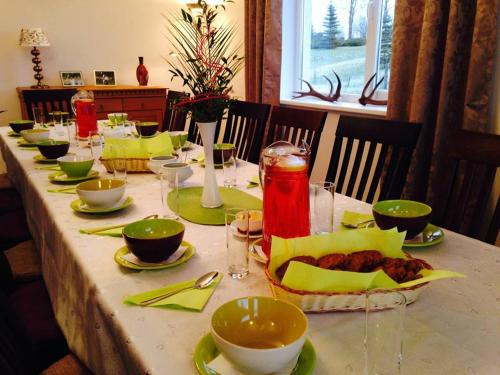 a long table with plates and bowls of food on it at More Guesthouse in More