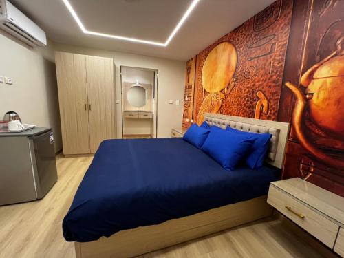 a bedroom with a blue bed with a wall at Pyramids View Inn in Cairo
