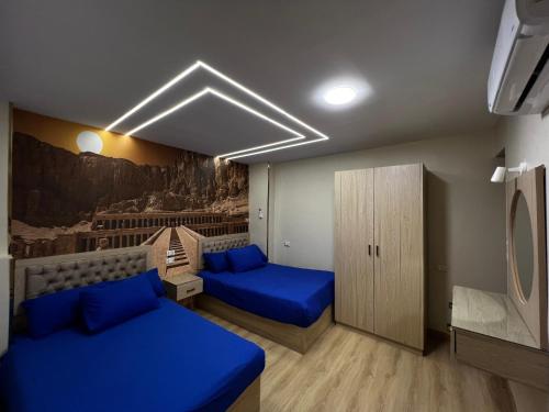 a room with two beds with blue pillows at Pyramids View Inn in Cairo