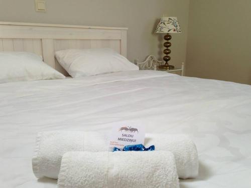 a bed with white sheets and towels on it at More Guesthouse in More