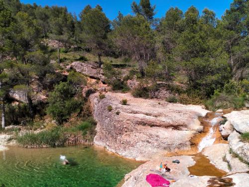 a group of people swimming in a body of water at Alojamiento La Fresneda in La Fresneda