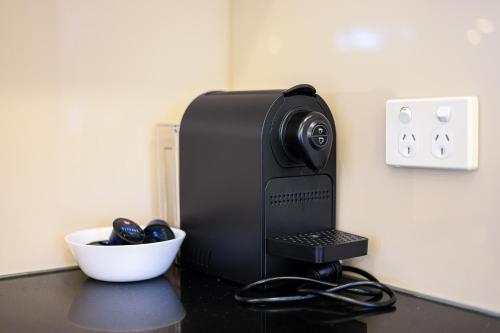 a computer printer sitting on a counter next to a bowl at StayAU Pakenham Townhouse with Lakeview in Pakenham
