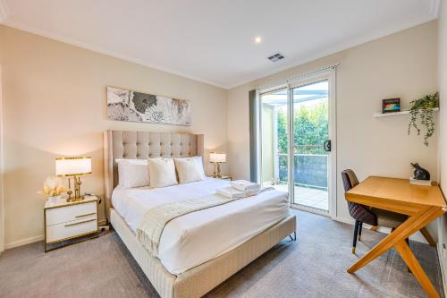 a bedroom with a bed and a desk and a window at StayAU Pakenham Townhouse with Lakeview in Pakenham