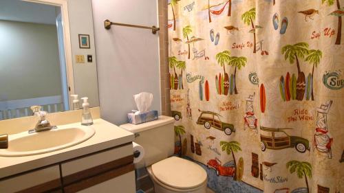 Un baño con lavabo, inodoro y cortina de ducha. en Capers #103, en Cape May