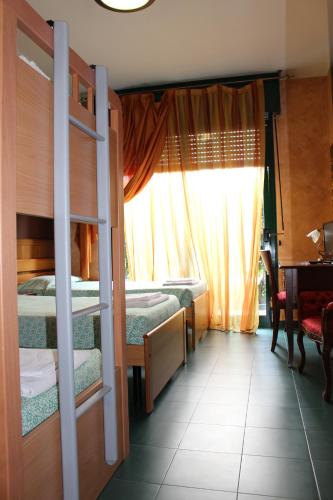 a room with two bunk beds and a window at Da Mariuccia in Robecchetto con Induno
