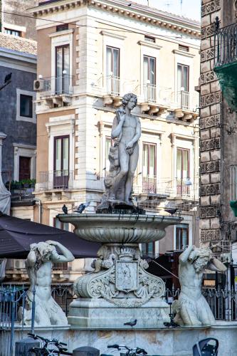 a fountain in front of a building with a statue at Dimora Di Nardo in Catania
