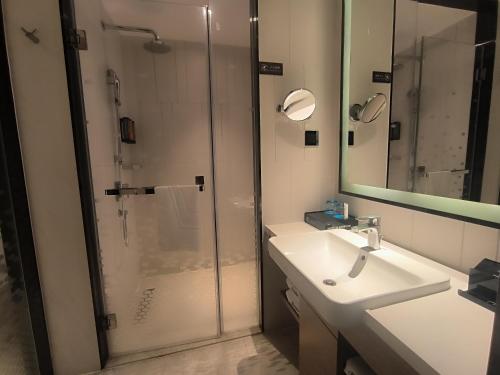 a bathroom with a shower and a sink and a mirror at Hampton by Hilton Guangzhou Zhujiang New Town - Free Shuttle Bus to Canton Fair in Guangzhou