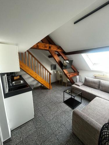 a living room with a couch and a staircase at Boutique-garni Hotel Papillon in Kempen