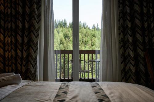 a bedroom with a bed in front of a large window at Goral Hotel & Spa in Bukovel