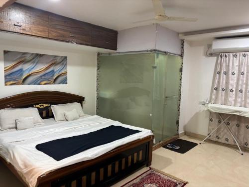 a bedroom with a bed and a glass shower at 2BHK penthouse Majestic Heights in Hyderabad