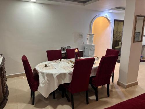 a dining room with a table and red chairs at 2BHK penthouse Majestic Heights in Hyderabad