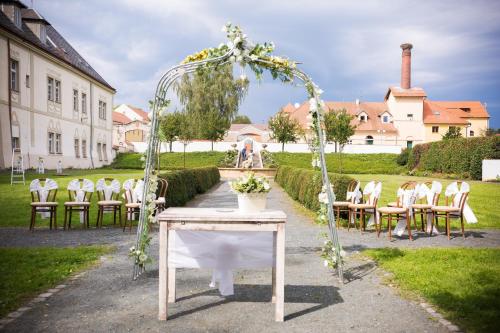 an arbor with chairs and a table with a wedding at Zámek Spálené Poříčí in Spálené Poříčí