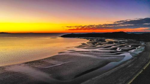 a sunset over a beach with the ocean at Ingenia Holidays Kinka Beach Yeppoon in Kinka