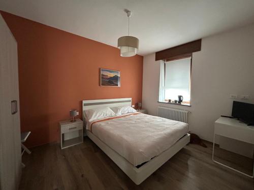 a bedroom with a white bed and a window at Stella Alpina in Paularo