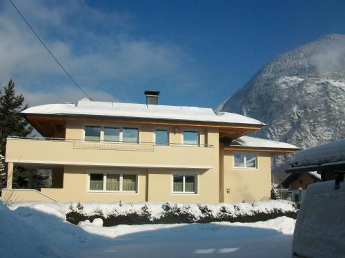 ein Haus im Schnee mit einem Berg dahinter in der Unterkunft Haus Falkner Barbara in Umhausen