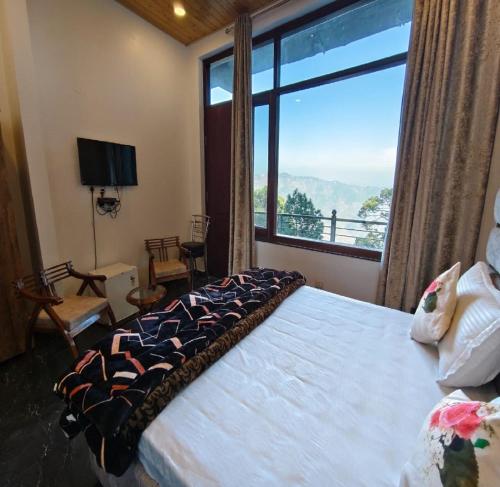 a bedroom with a large bed with a large window at Claremont Homestay By StayApart in Kasauli