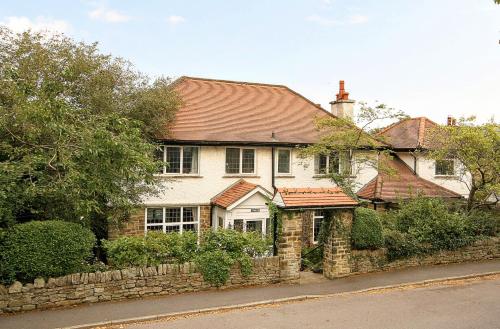 a large white house with a stone wall at Vintage vibe with modern conveniences - Sheffield & Peak District! in Stannington