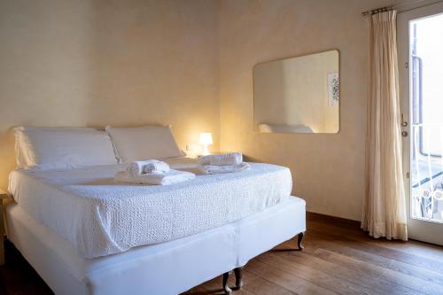 a bedroom with a white bed with towels on it at Angolo sui tetti a Pietrasanta in Pietrasanta