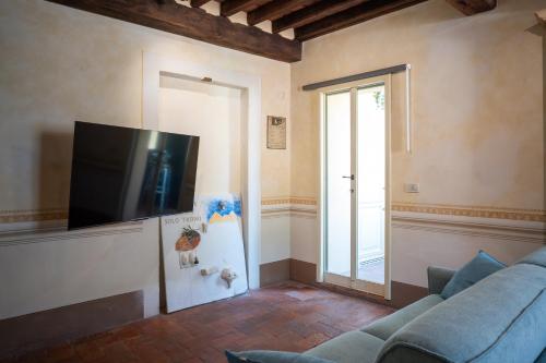 a living room with a couch and a flat screen tv at Angolo sui tetti a Pietrasanta in Pietrasanta