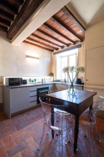 a kitchen with a table with a vase on it at Angolo sui tetti a Pietrasanta in Pietrasanta