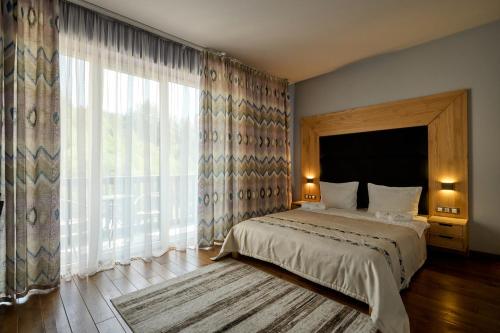 a bedroom with a bed and a large window at Goral Hotel & Spa in Bukovel