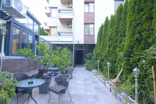 an outdoor patio with tables and chairs and plants at Cvetni konaci-Lenka in Vrnjačka Banja