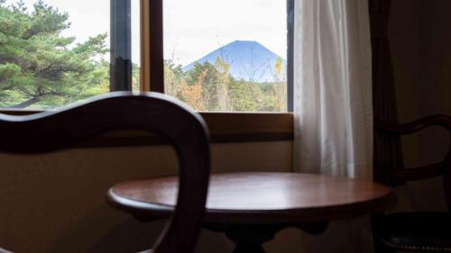 a wooden chair sitting in front of a window at Motosu Phoenix Hotel in Fujikawaguchiko