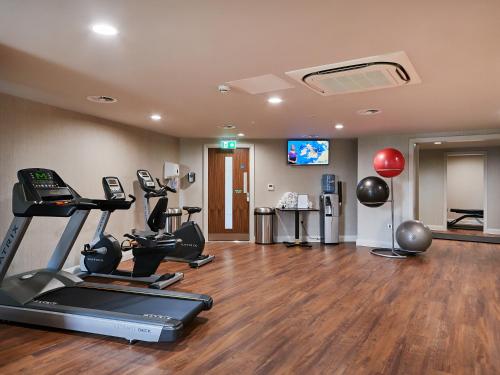 a gym with treadmills and exercise equipment in a room at Park Regis Birmingham in Birmingham