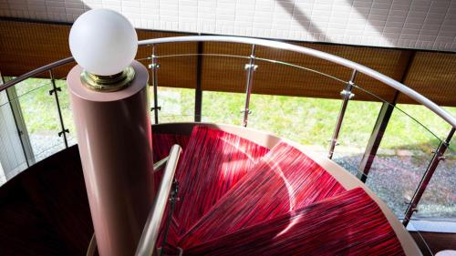 a pole with a red umbrella in front of a window at Motosu Phoenix Hotel in Fujikawaguchiko