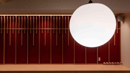 a room with a red wall with a large orb at Motosu Phoenix Hotel in Fujikawaguchiko