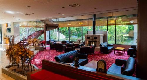 a lobby with couches and a fireplace and a staircase at Motosu Phoenix Hotel in Fujikawaguchiko
