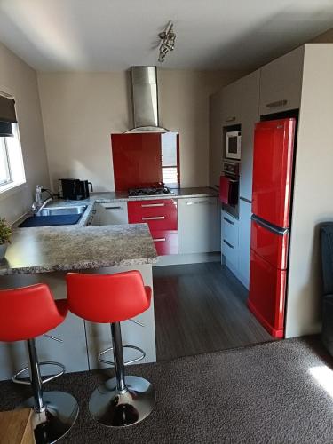 a kitchen with red cabinets and a red refrigerator at Executive Hideaway in Christchurch