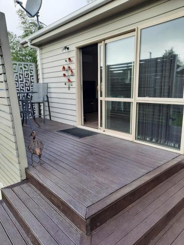 a duck walking on a wooden deck with a house at Executive Hideaway in Christchurch
