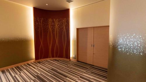 a bedroom with a bed and a curtain at Motosu Phoenix Hotel in Fujikawaguchiko