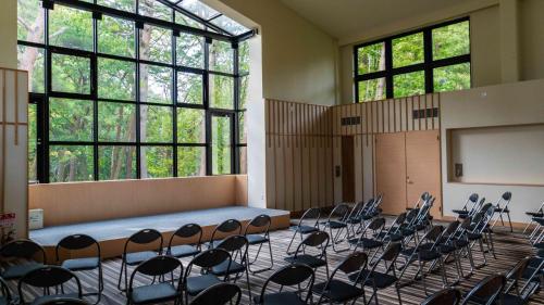 a room with chairs and a podium in a classroom at Motosu Phoenix Hotel in Fujikawaguchiko