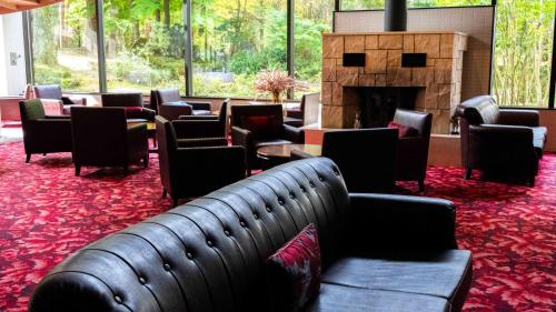a waiting room with couches and a fireplace at Motosu Phoenix Hotel in Fujikawaguchiko