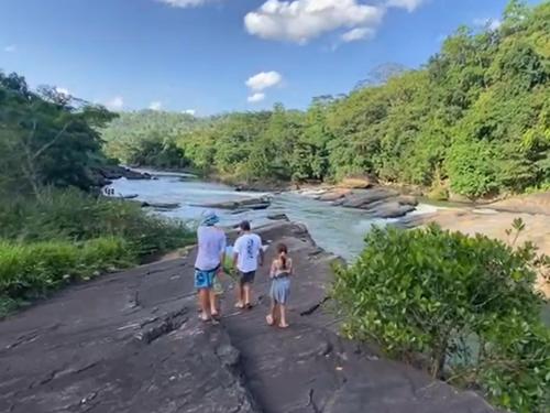 a group of three people standing on a bridge over a river at Aqua Dunhinda Nature Retreat in Kandy