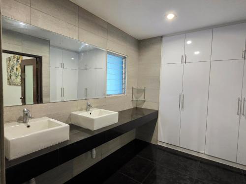 a bathroom with two sinks and a large mirror at Bungalow Perkasa Kuala Lumpur in Kuala Lumpur