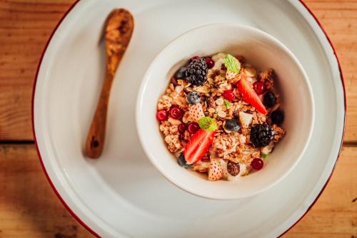 a bowl of granola with berries and a spoon at Radisson RED Brussels in Brussels