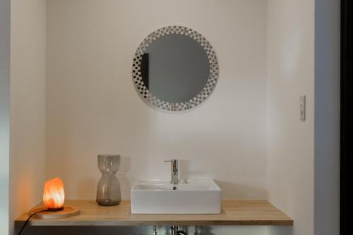 a bathroom with a sink and a mirror on the wall at Forest and Stars Akakura Sauna in Myoko
