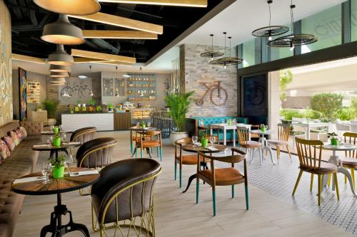 a rendering of a restaurant with tables and chairs at Adagio Premium The Palm in Dubai
