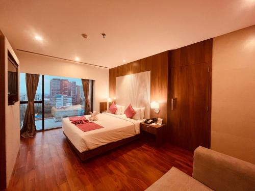 a hotel room with a bed and a large window at Hotel Senses in Kolkata