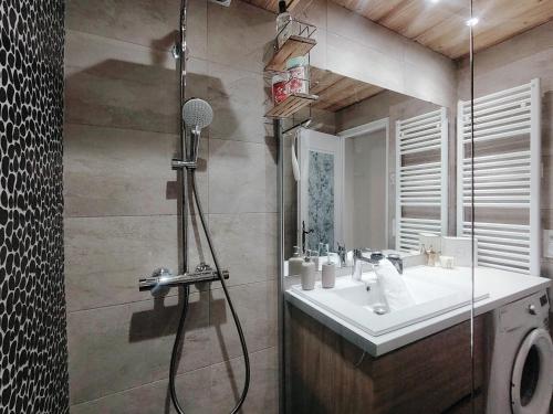 une salle de bain avec un lavabo et une douche avec un miroir dans l'établissement Homency - Résidence Les Gémeaux A5, à L'Alpe-d'Huez