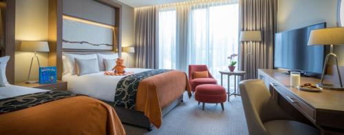 una camera d'albergo con due letti e una televisione di Clayton Hotel Galway a Galway
