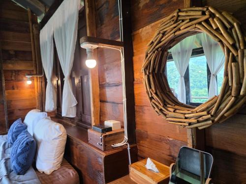 a room with a mirror and a bed and a chair at บ้านไร่ไอดอย in Phrae